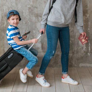 anne taşıma bekleme odasında bir bavul üzerinde küçük bir oğlu taşır.