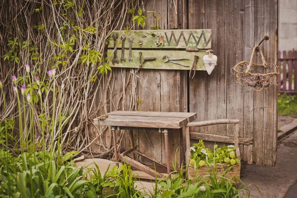 design of the photo zone in a rustic style, old wooden doors and boards with tools and spring flowers.