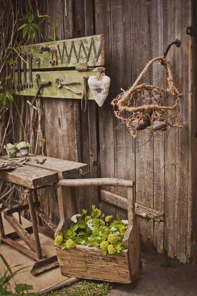 design of the photo zone in a rustic style, old wooden doors and boards with tools and spring flowers.