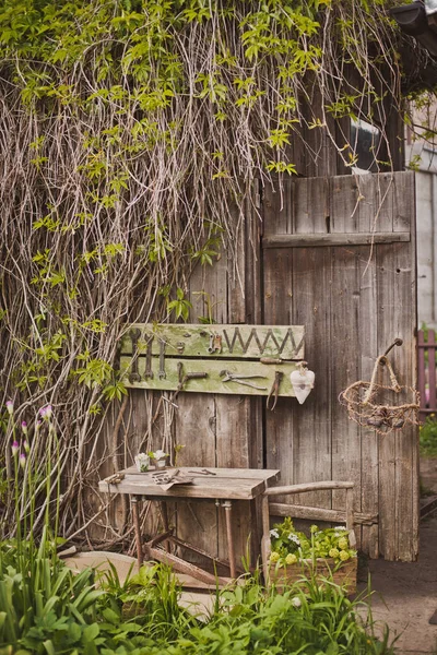 Progettazione della zona foto in stile rustico, vecchie porte e tavole in legno con strumenti e fiori primaverili . — Foto Stock