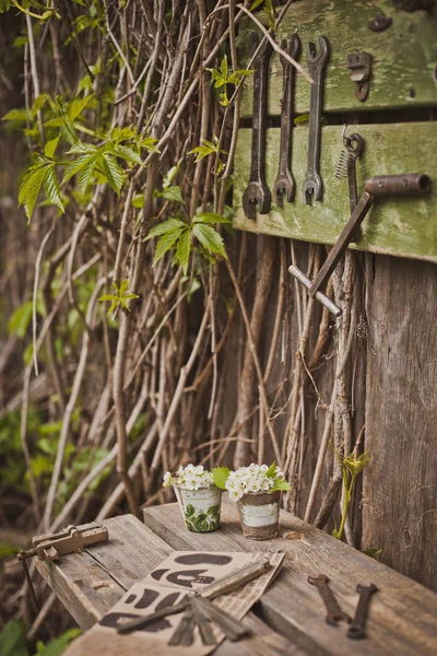 Дизайн фотозони в сільському стилі, старі дерев'яні двері і дошки з інструментами і весняними квітами . — стокове фото