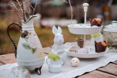 Servis şenlikli dekoratif masa bahçesi açık havada. Çiftlik. Rustik tarz. Söğüt baharı çiçek açar. Çiçekler çerezleri cam kavanoz. Paskalya