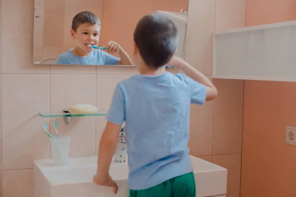 Criança feliz ou criança escovando os dentes no banheiro . — Fotografia de Stock