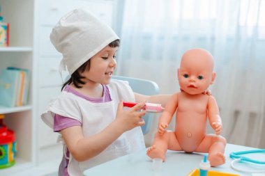 Küçük kız 3 yaşında okul öncesi bebek ile doktor oynuyor. Th