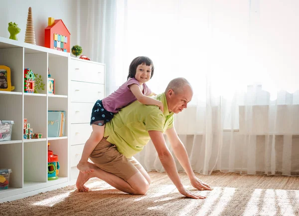 Père joue à la maison avec sa jolie petite fille. Joyeuse fête des pères — Photo