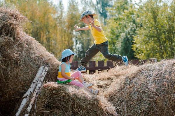 Kinder tummeln sich in den Sommerferien auf dem Heuboden des Dorfes. — Stockfoto