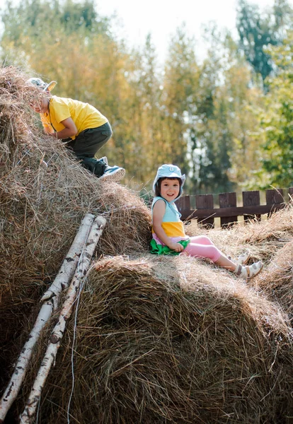 Kinder tummeln sich in den Sommerferien auf dem Heuboden des Dorfes. — Stockfoto