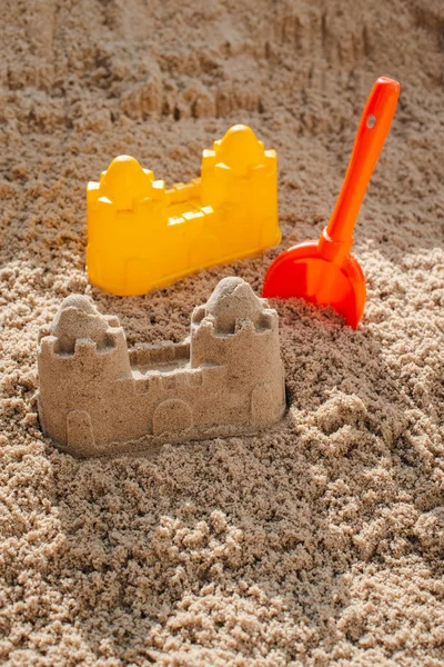 Children toys for build the sandcastle, Shovel, Molds laying on the sand at the seashore, — Stock Photo, Image