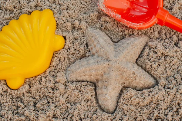 Children toys for build the sandcastle, Shovel, Molds laying on the sand at the seashore, — Stock Photo, Image