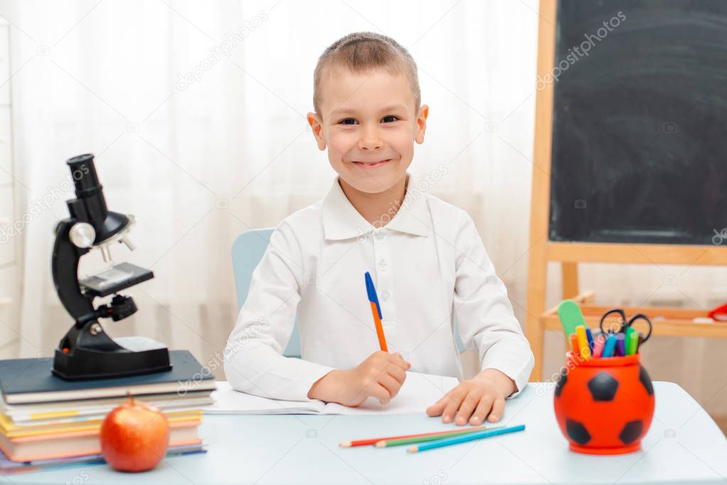 school boy sitting at home classroom lying desk filled with books training material schoolchild sleeping lazy bored