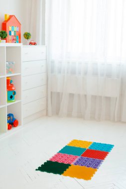 Bebek ayak masajı minderinde yeni yürümeye başlayan çocuk. Ortopedik masaj halısı üzerinde bacak egzersizleri. Düz taban ve halluks valgus önleme