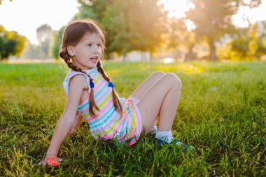 Mutlu bebek yaz Parkı'nda yeşil çimenler üzerinde baş aşağı duruyor.