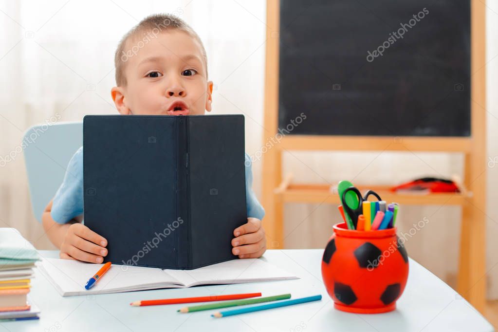 school boy sitting at home classroom lying desk filled with books training material schoolchild sleeping lazy bored