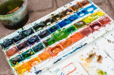 yaratıcı sanatçı renkli bir resim çizer. Açık havada boyama işleminde ellerin ve fırçanın yakın çekim