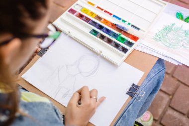 yaratıcı sanatçı renkli bir resim çizer. Açık havada boyama işleminde ellerin ve fırçanın yakın çekim