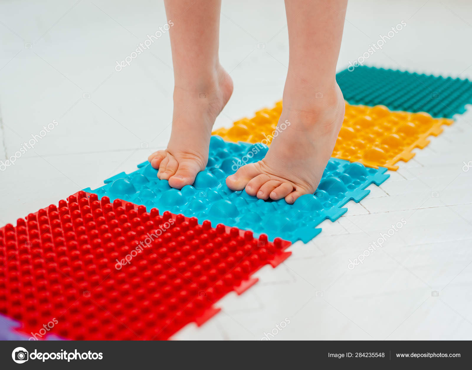 Niño en la alfombra de masaje del pie del Ejercicios para