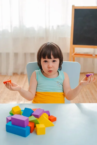 Mała dziewczynka kolekcjonuje drewnianą, niemalowaną piramidę. Bezpieczne naturalne drewniane zabawki dla dzieci. — Zdjęcie stockowe