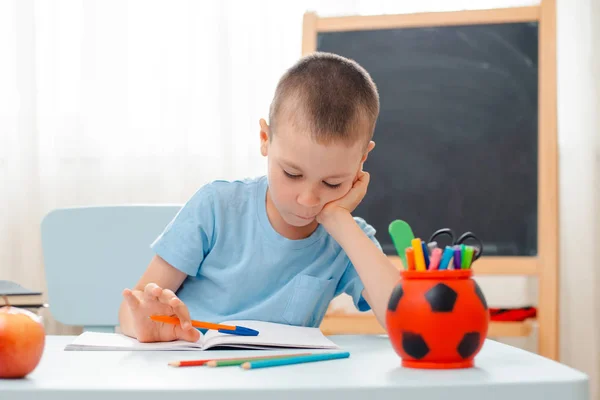 Niño de la escuela sentado en el aula de casa tumbado escritorio lleno de libros material de formación escolar durmiendo perezoso aburrido — Foto de Stock