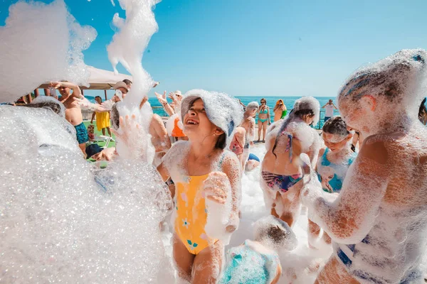 Russia, Tuapse 4 luglio 2019. I bambini si divertono a una festa in schiuma sulla spiaggia . Fotografia Stock