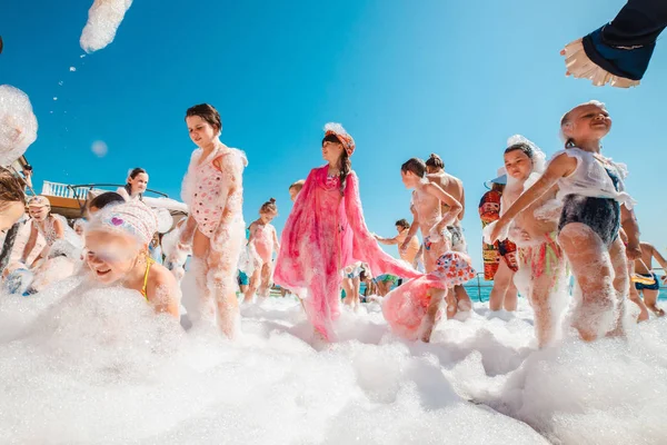 Russia, Tuapse 4 luglio 2019. I bambini si divertono a una festa in schiuma sulla spiaggia . Fotografia Stock