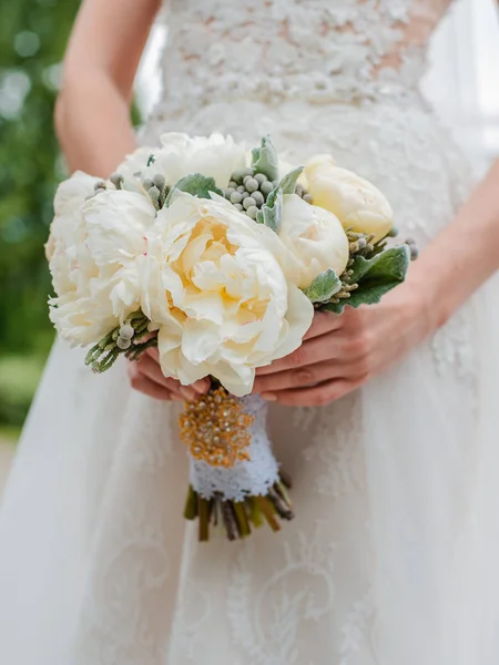 Nygifta par. Bröllopsdag. Bukett av bruden i händerna, brudgummens omfamning. — Stockfoto