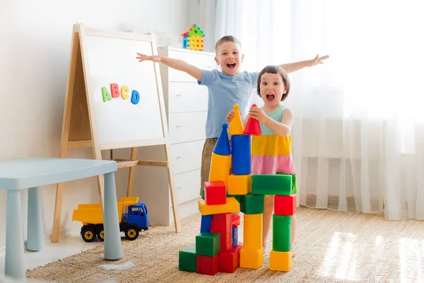 Щасливі діти дошкільного віку грають з іграшковими блоками . — стокове фото