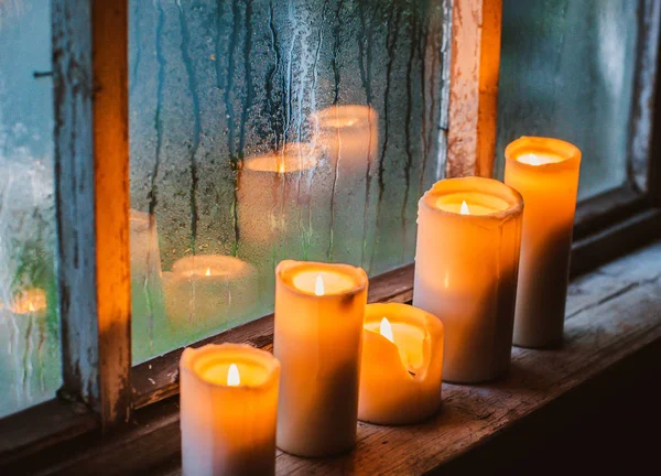 Piękne tło z kroplami deszczu na oknie i płonące świece. — Zdjęcie stockowe