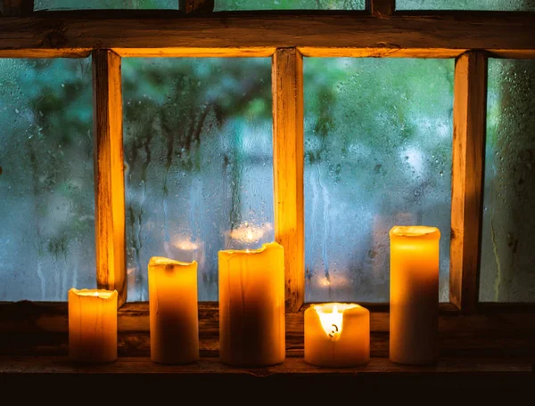 Piękne tło z kroplami deszczu na oknie i płonące świece. — Zdjęcie stockowe