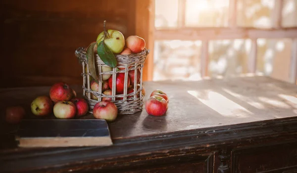 Färsk skörd av mogna och friska äpplen i en glasburk, i en korg. — Stockfoto