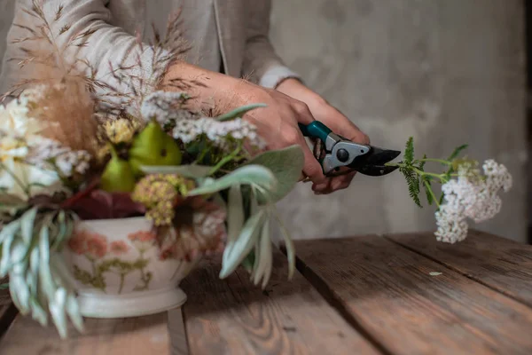 Kobieta profesjonalny kwiaciarnia przygotowuje układ dzikich kwiatów. — Zdjęcie stockowe