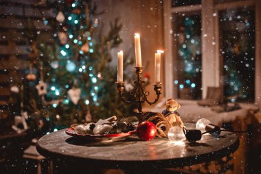 Işıklar ve Noel ağacıarka üzerinde mumlar ve antika süslemeleri ile yeni yıl gece masa dekorasyonu