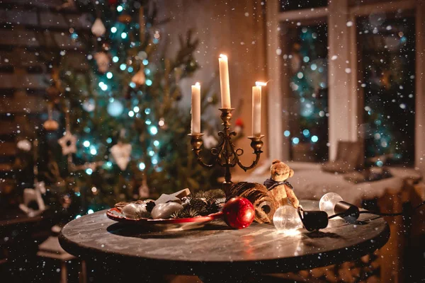 Año nuevo decoración de la mesa de noche con velas y decoraciones antiguas en el fondo de las luces y el árbol de Navidad —  Fotos de Stock