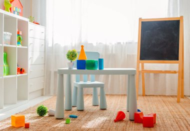 Beyaz ahşap zemin ve büyük ve hafif bir pencere ile basit bir çocuk odasında boş bir duvarın alanı kopyalayın.