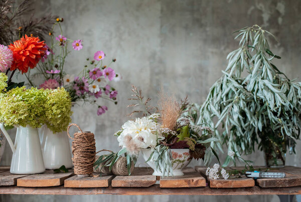 large floral arrangement bouquet on the desktop florist on the background of a concrete wall