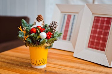 beton bir arka plan üzerinde kırmızı bir Fincan ve Noel oyuncakları köknar dalları buket.