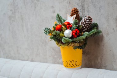 beton bir arka plan üzerinde kırmızı bir Fincan ve Noel oyuncakları köknar dalları buket.