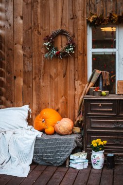 Terasta dekoratif tasarım penceresi. Sonbahar çelengi ve balkabağı ahşap kırsal arka planda eski bir çekmece sandığı.