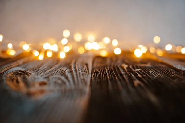 Pusty stary drewniany blat z zamazanym złotym bokeh Christmas lights abstrakcyjne tło. — Zdjęcie stockowe