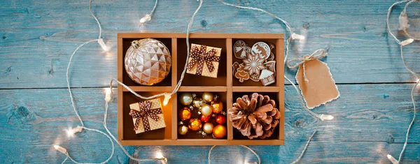 Decoraciones de Navidad están en una caja sobre un fondo de madera azul. — Foto de Stock