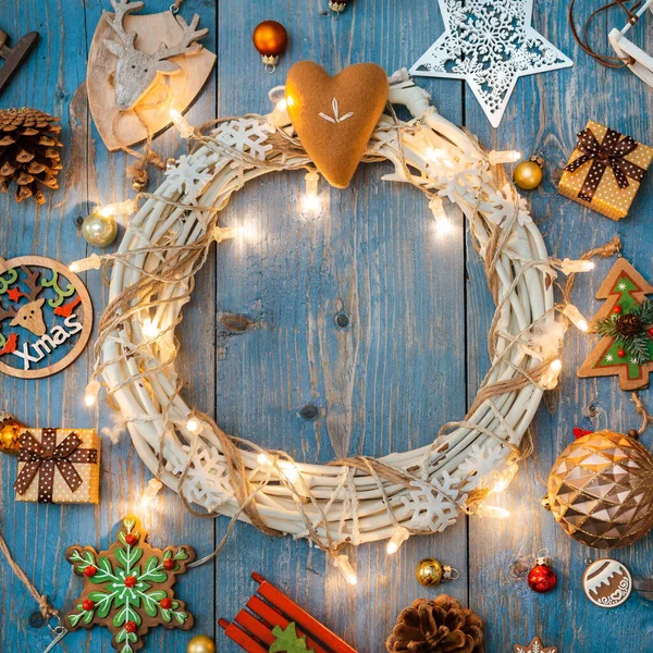 Újévi dekorációk körül karácsonyi koszorú kék fa háttér. — Stock Fotó