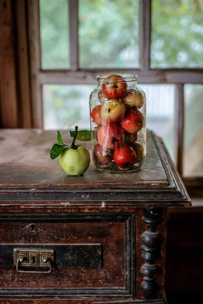 Färsk skörd av mogna och friska äpplen i en glasburk, i en korg. — Stockfoto