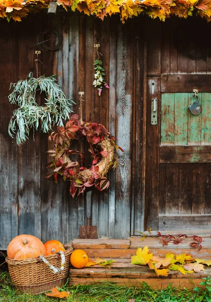 Fall på verandan. höst krans och pumpor på gamla trä rustik bakgrund vid dörrar. — Stockfoto