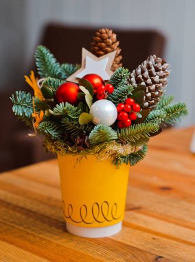 beton bir arka plan üzerinde kırmızı bir Fincan ve Noel oyuncakları köknar dalları buket.