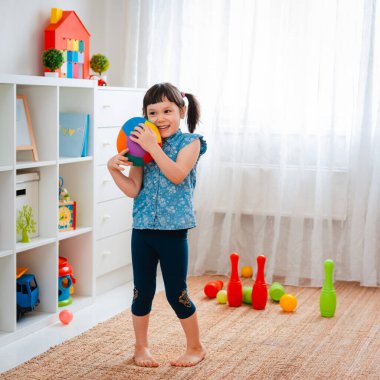 Çocuklar oyun odasında top oynayan küçük bir kız çocuğu. etkileşim konsepti ebeveyn ve çocuk, iletişim, karşılıklı oyun, karantina, kişisel izolasyon evi, eğitim.