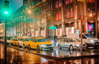 Islak şehir sokağı yağmuru Bokeh yansıması parlak renkli ışıklar kaldırım arabasının farları ıslak asfalt yol trafiği trafik sıkışıklığını aydınlatıyor. Rusya Moskova 05 Kasım 2019.