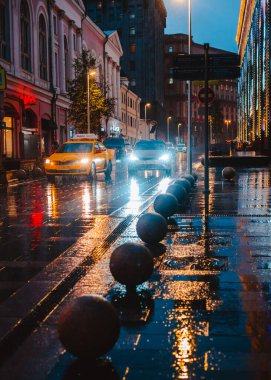 Islak şehir sokağı yağmuru Bokeh 'in yansıması parlak renkli ışıklar kaldırım araba farları ıslak asfalt yolu aydınlatıyor seçici odak bulanıklığını gideriyor. Rusya Moskova 05 Kasım 2019.