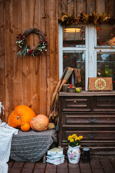 Terasta dekoratif tasarım penceresi. Sonbahar çelengi ve balkabağı ahşap kırsal arka planda eski bir çekmece sandığı.