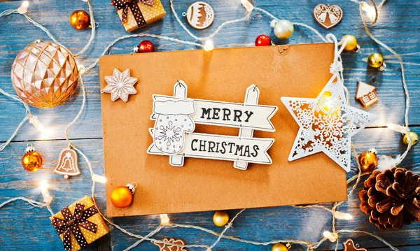青い木製の背景にテキスト燃焼ライトガーランドのためのクリスマスの手紙空のスペースの周りの新年の装飾 上からの眺め 平置きだ コピースペースブラウン素朴なスタイル — ストック写真
