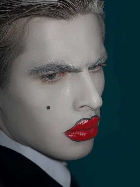 portrait of male model with white face and red lips