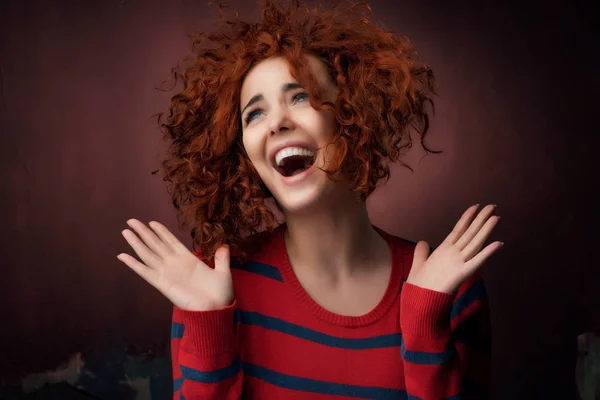赤毛の若い女性がスタジオでポーズ開いて手と笑い — ストック写真